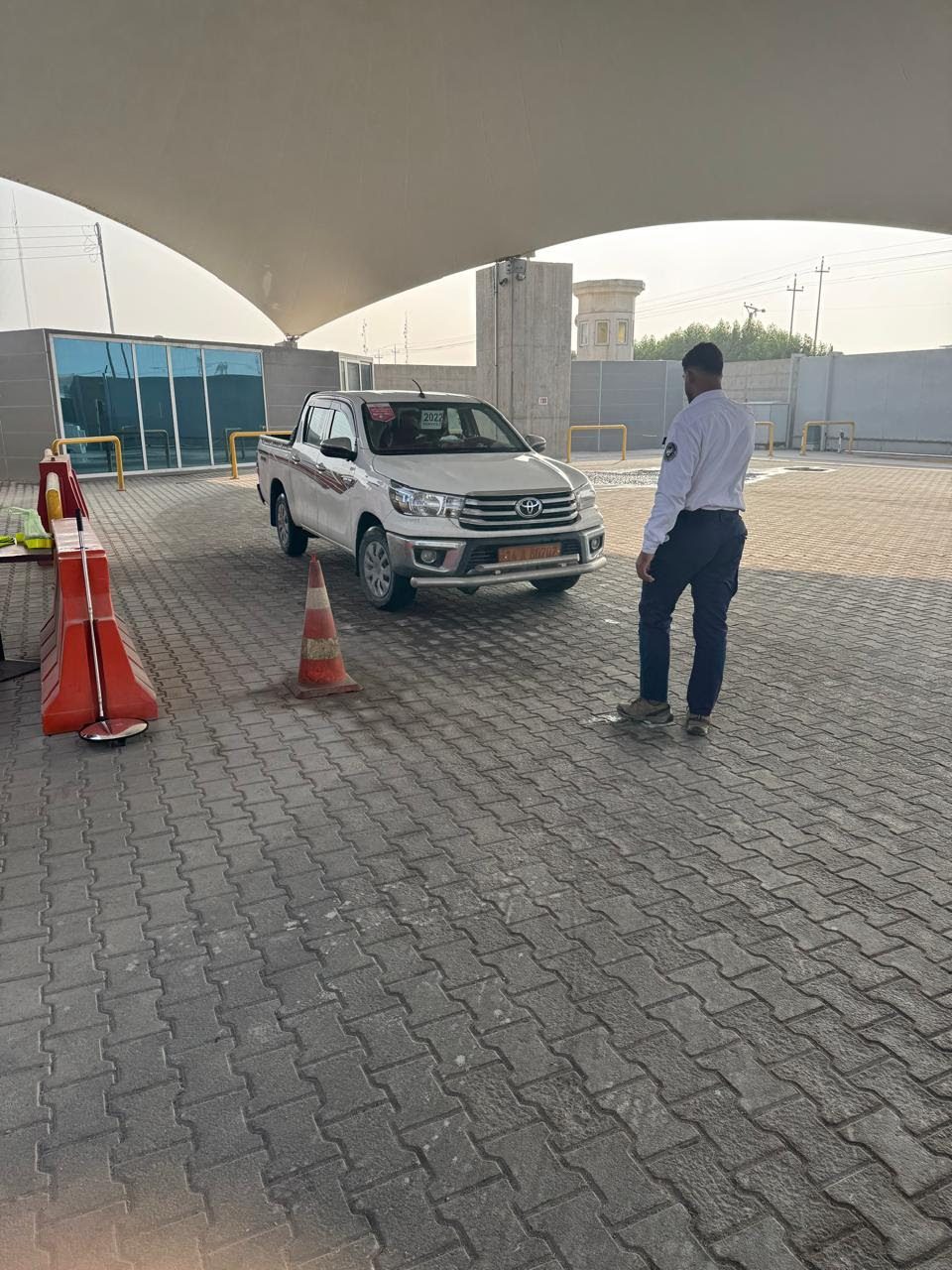 حارس يوقف مركبة في ممر نقطة التفتيش