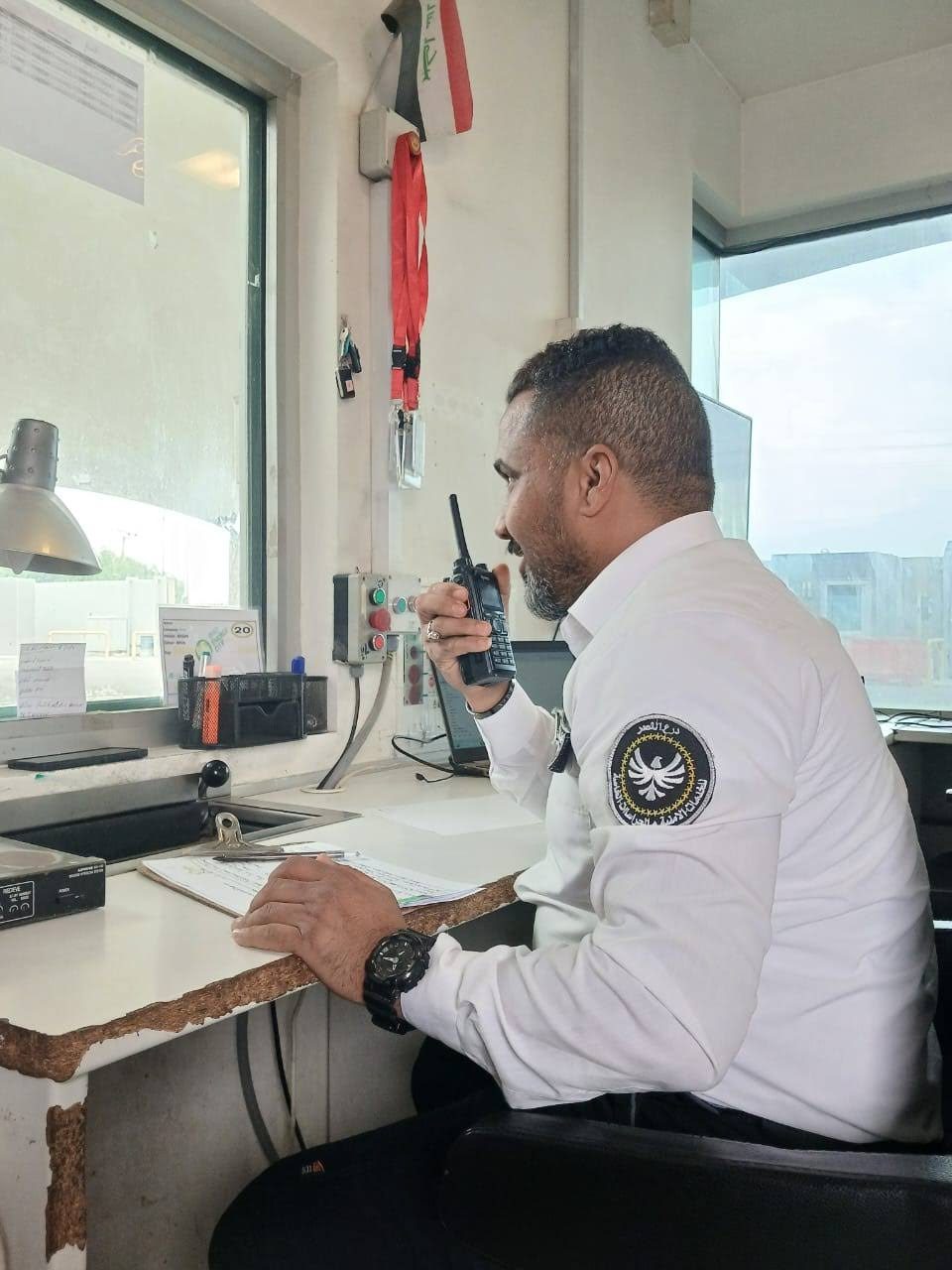 A guard on the radio at the Iraq Energy City gatehouse