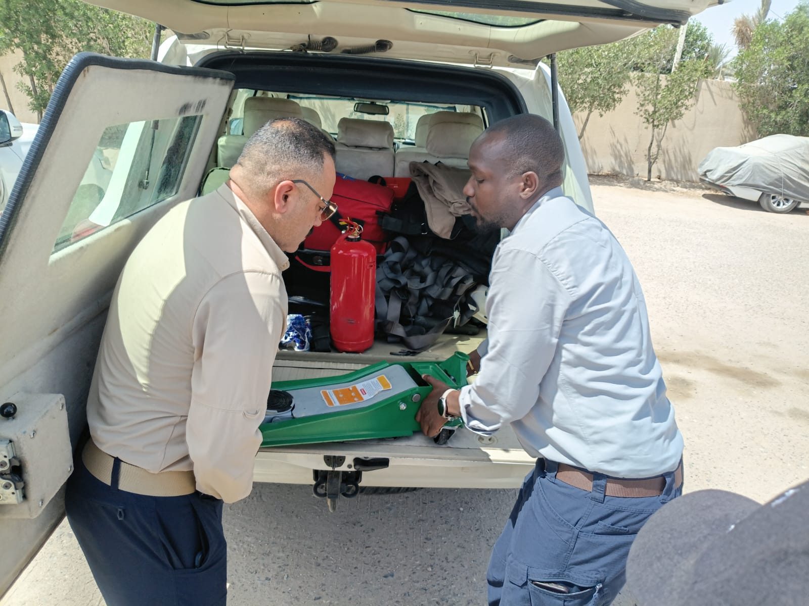 Two team members unload the recovery jack from a vehicle