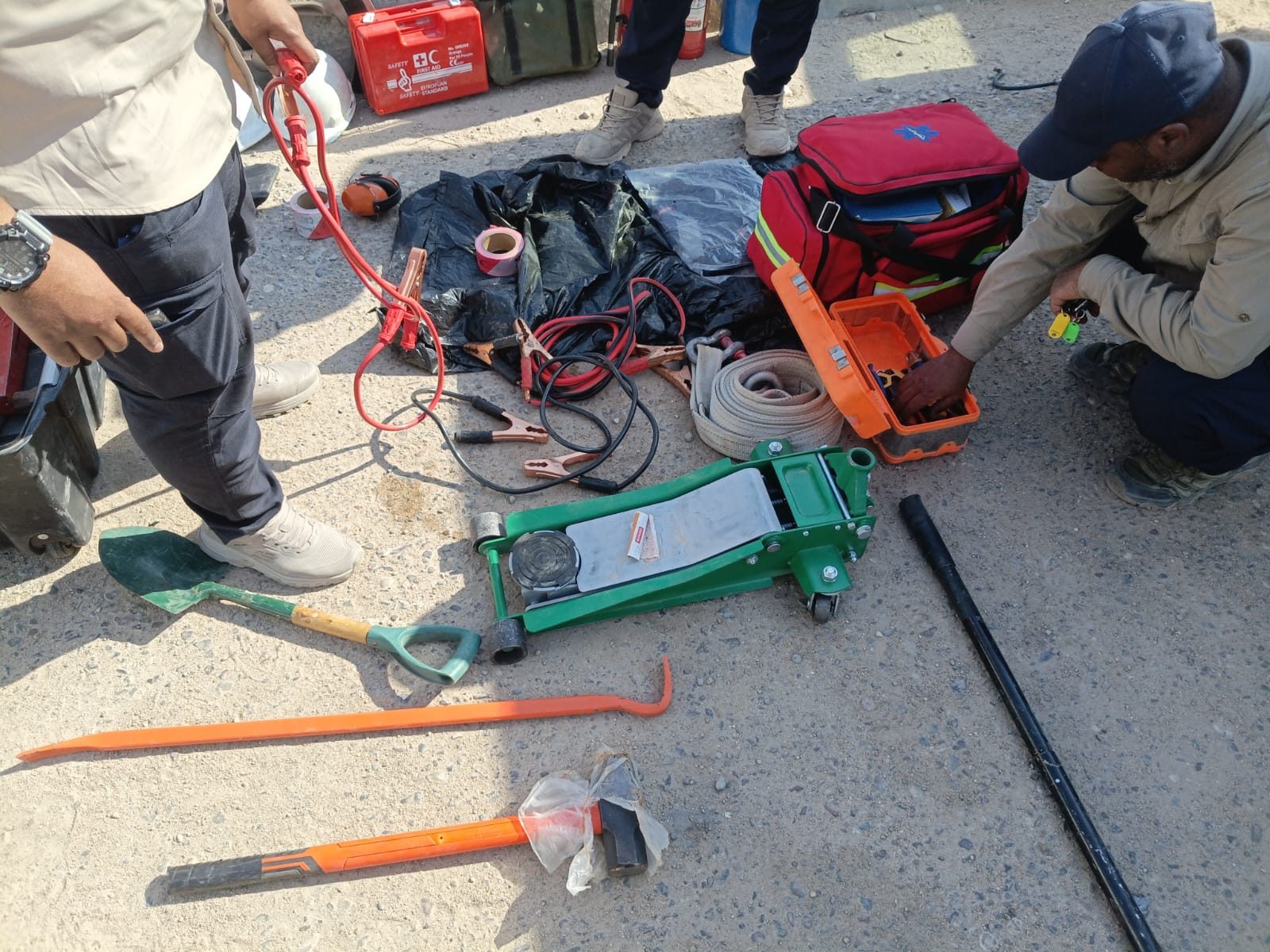 The team checks recovery equipment and a trauma bag beside the vehicle