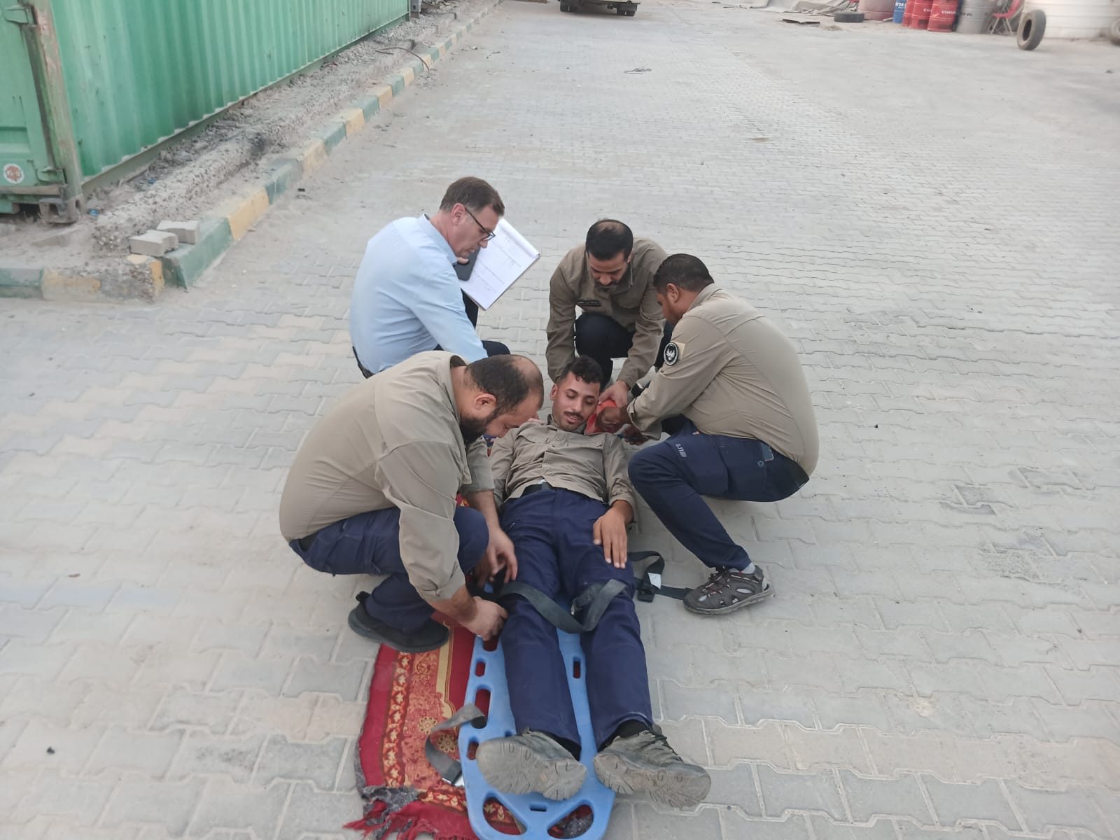 The team secures a casualty on a spine board during a drill