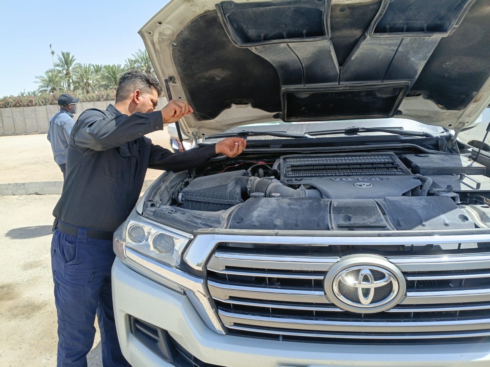 A team member checks a vehicle engine before a move